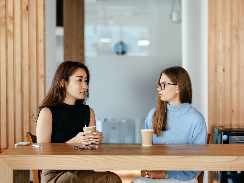 Two women drinking coffee and talking.