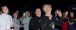 A group of people running in the dark. A man at the front, Matt Dingjan is wearing a shirt that says 'Doing it for Debbie'