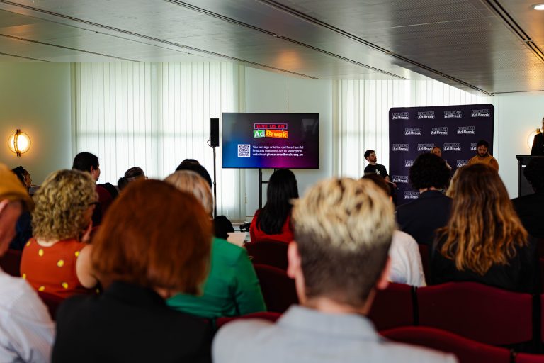 A wide shot of a room inside parliament house, showing a crowd gathered for the Give Us An Ad Break launch event.