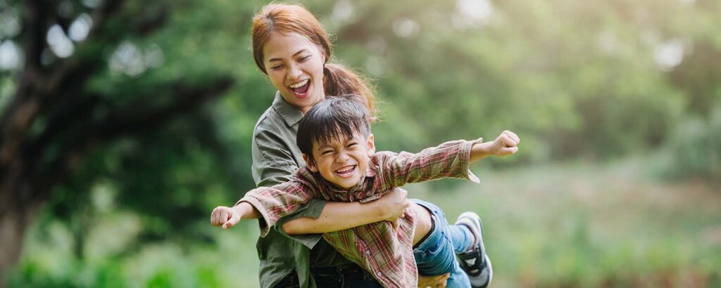 A mother and her young son playing together in a park