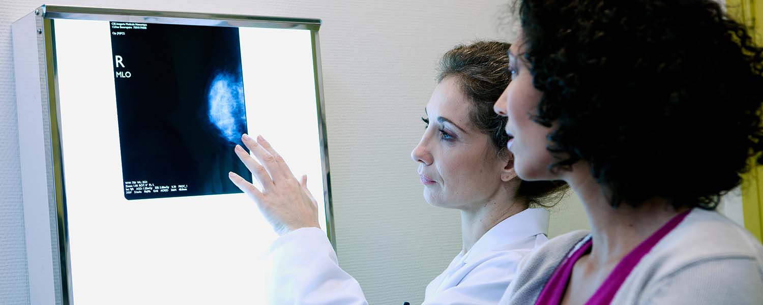 Female doctor showing a scan to a female patient