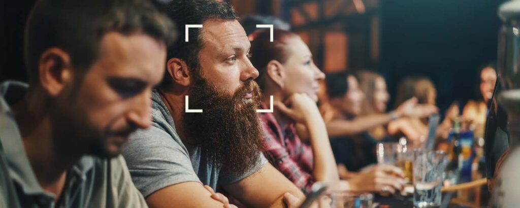 Man sitting at crowded bar with a box highlighting his face