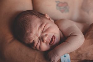 A man cradling a baby in his arms.