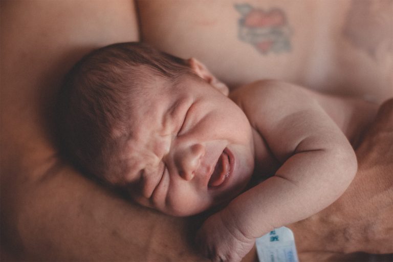 A man cradling a baby in his arms.